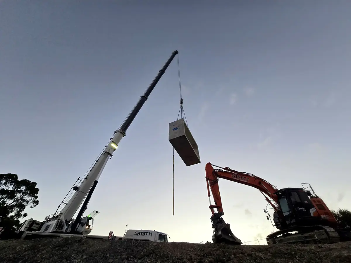 A Direct Drains digger works alongside a crane at an EarthCo culvert project